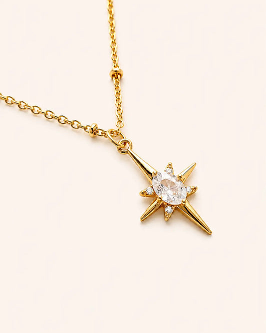 Gold necklace with a star-shaped pendant on a white background