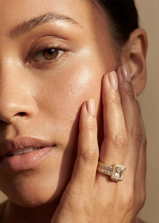 Woman wearing a ring on her finger against a beige background