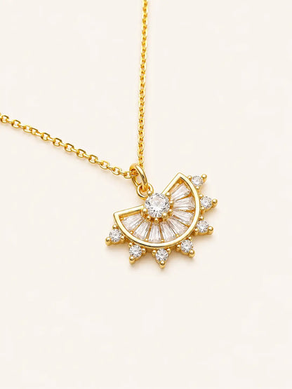 Gold necklace with a sun-shaped pendant on a light beige background