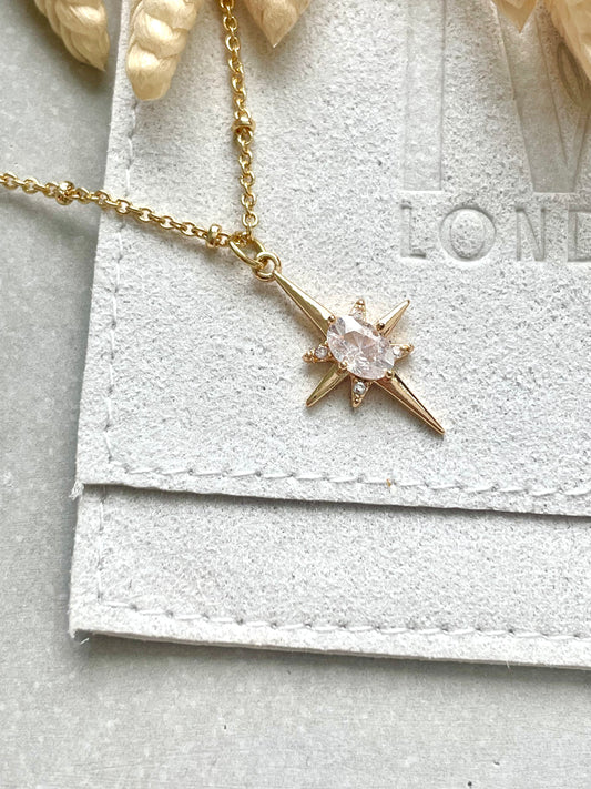 An 18k gold plated cubic zirconia necklace with a star-shaped pendant, displayed on a white textured background, with a tag that reads 'LONDON'.