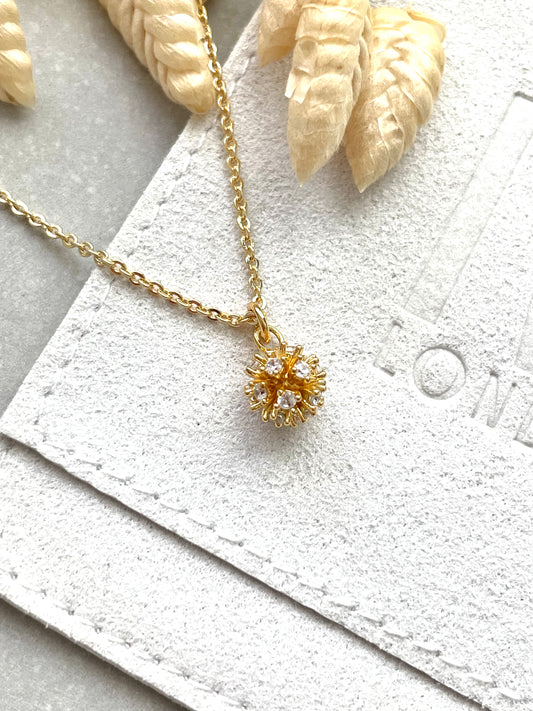A gold-plated cubic zirconia spike ball necklace with a chain, displayed on a white background.