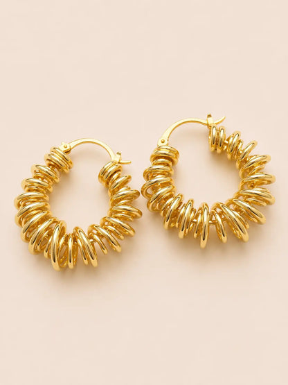 Gold hoop earrings on a beige background