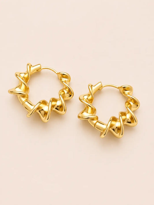 Pair of gold hoop earrings on a beige background
