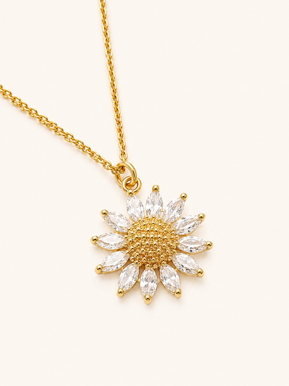 Gold necklace with a sunflower-shaped pendant on a white background