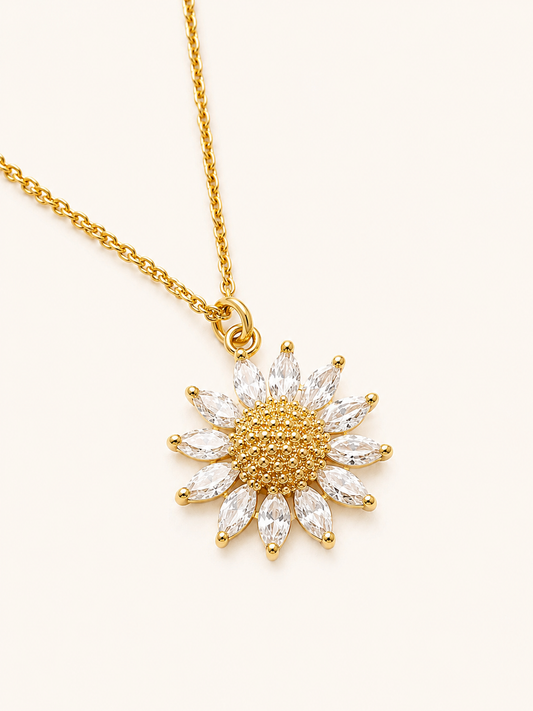 Gold necklace with a sunflower-shaped pendant on a white background